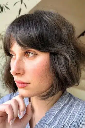 Softly textured French bob on a woman with brown hair, side view