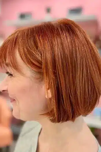 Classic French bob on a woman with copper hair, side view