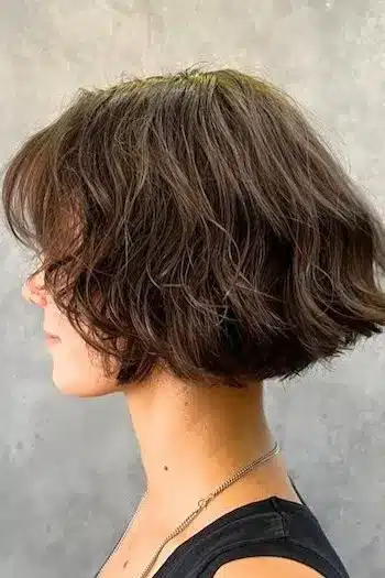 Classic French bob with textured finish on a woman with brown hair, side view