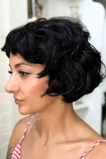 Voluminous French bob with curly ends on a woman with brown hair, side view