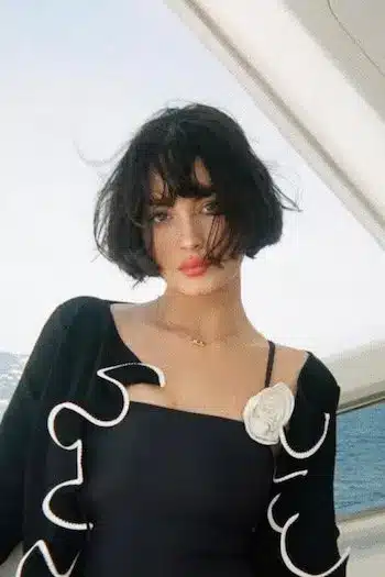 Windswept French bob on a woman with brown hair standing on a boat