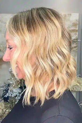 Blonde wavy bob with dark roots for a grown-out, lived-in look