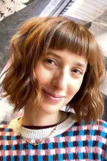 Wavy bob with short baby bangs and soft, bouncy curls