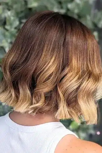 Brown-to-blonde ombré wavy bob with a smooth color transition, back view