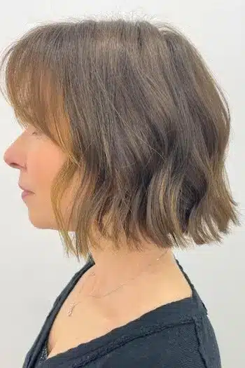 Wispy wavy bob with soft bangs and natural wave pattern, side view