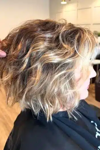 Voluminous wavy bob with face-framing highlights, side profile