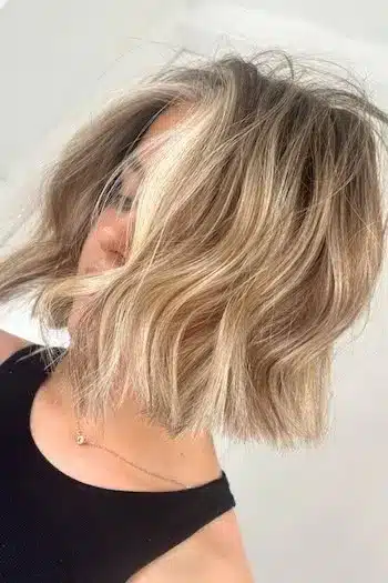 Tousled blonde wavy bob with a relaxed, undone finish, side profile