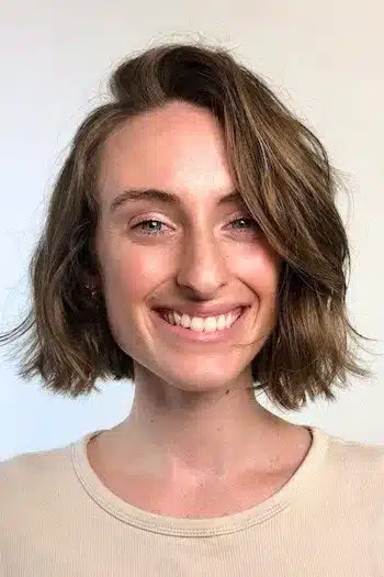 Tousled side-part wavy bob on a smiling woman with natural texture
