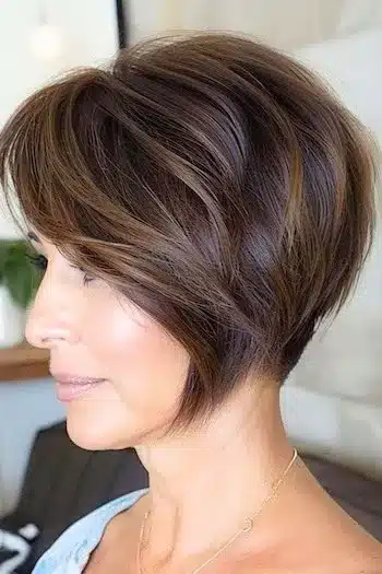 Soft layered wedge with side-swept bangs, side profile of a woman with brown hair