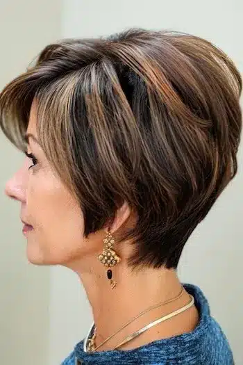 Tapered highlighted wedge haircut with brown and blonde tones, side view