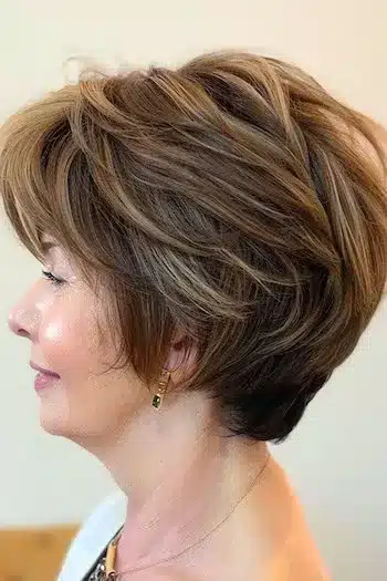 Bouffant wedge haircut with lifted crown, side view of a smiling woman
