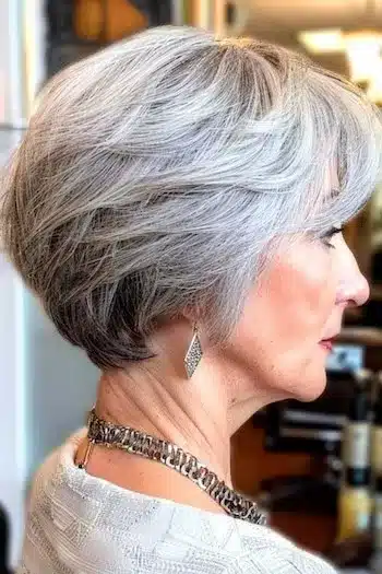 Feathered cropped wedge in natural gray, side profile of a woman with soft layers
