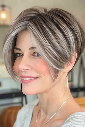 Salt and pepper wedge haircut with mixed gray and brown tones on a smiling woman