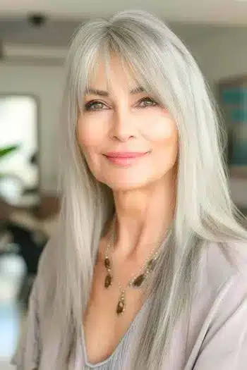 Long straight cut with bangs on a woman in her 60s with gray hair