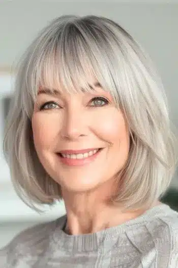 Bob with bangs on a smiling older woman with natural gray hair