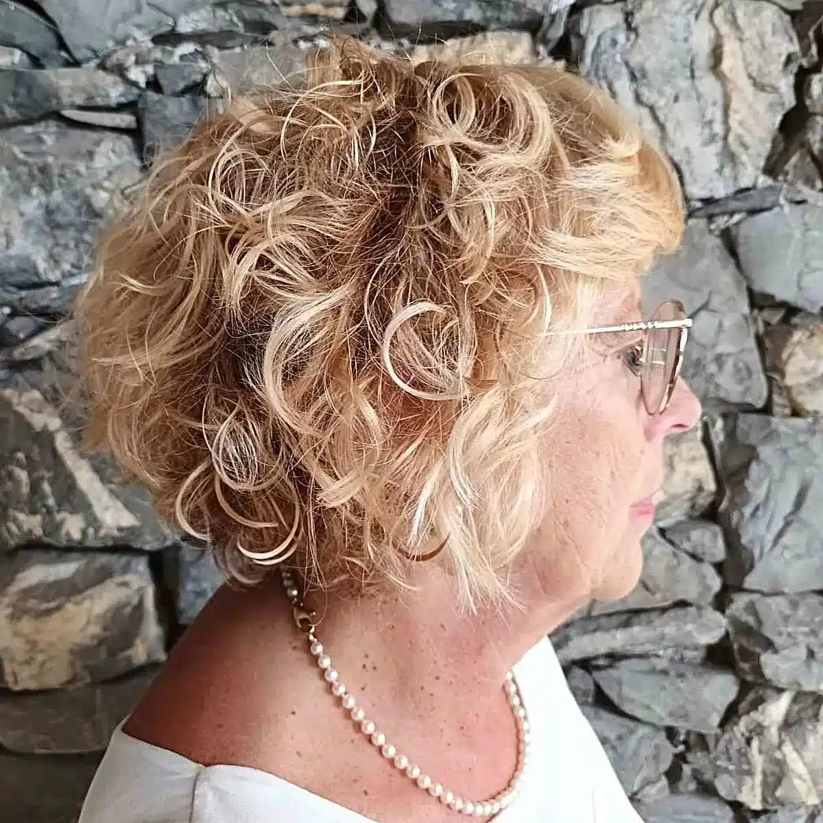 51 Cutest Wash and Wear Haircuts for Women Over 50 28 Jaw-Length Curly Inverted Bob with Bangs for Wash and Wear Women Over Fifty with Blonde Hair